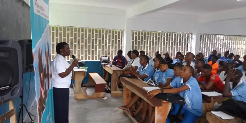 A speaker at the front of a classroom of secondary school students